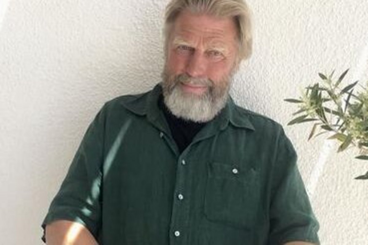 ein bärtiger, freundlich schauender grauhaariger Mann im gründen Hemd