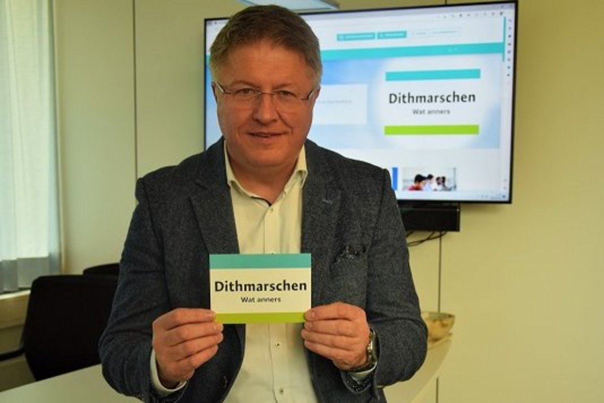 Auf dem Bild ist Landrat Stefan Mohrdieck. Er hält die Karte mit dem Claim "Dithmarschen Wat anners":: “Ich freue mich sehr, dass es uns gelungen ist, den Relaunch der Website mit dem Start der neuen Standortinitiative zu verbinden.“  Foto: Kreis Dithmarschen