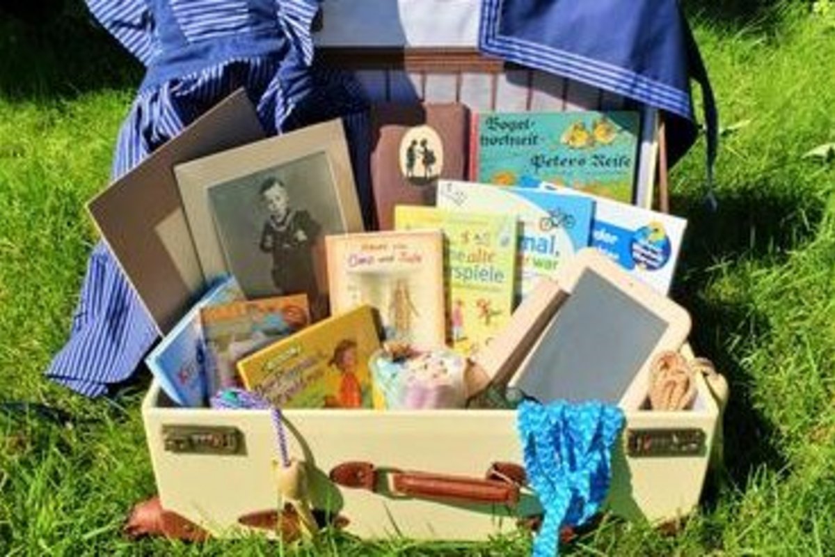 ein altmodischer Koffer mit alten Schulbüchern, Schreibtafel, Kreide