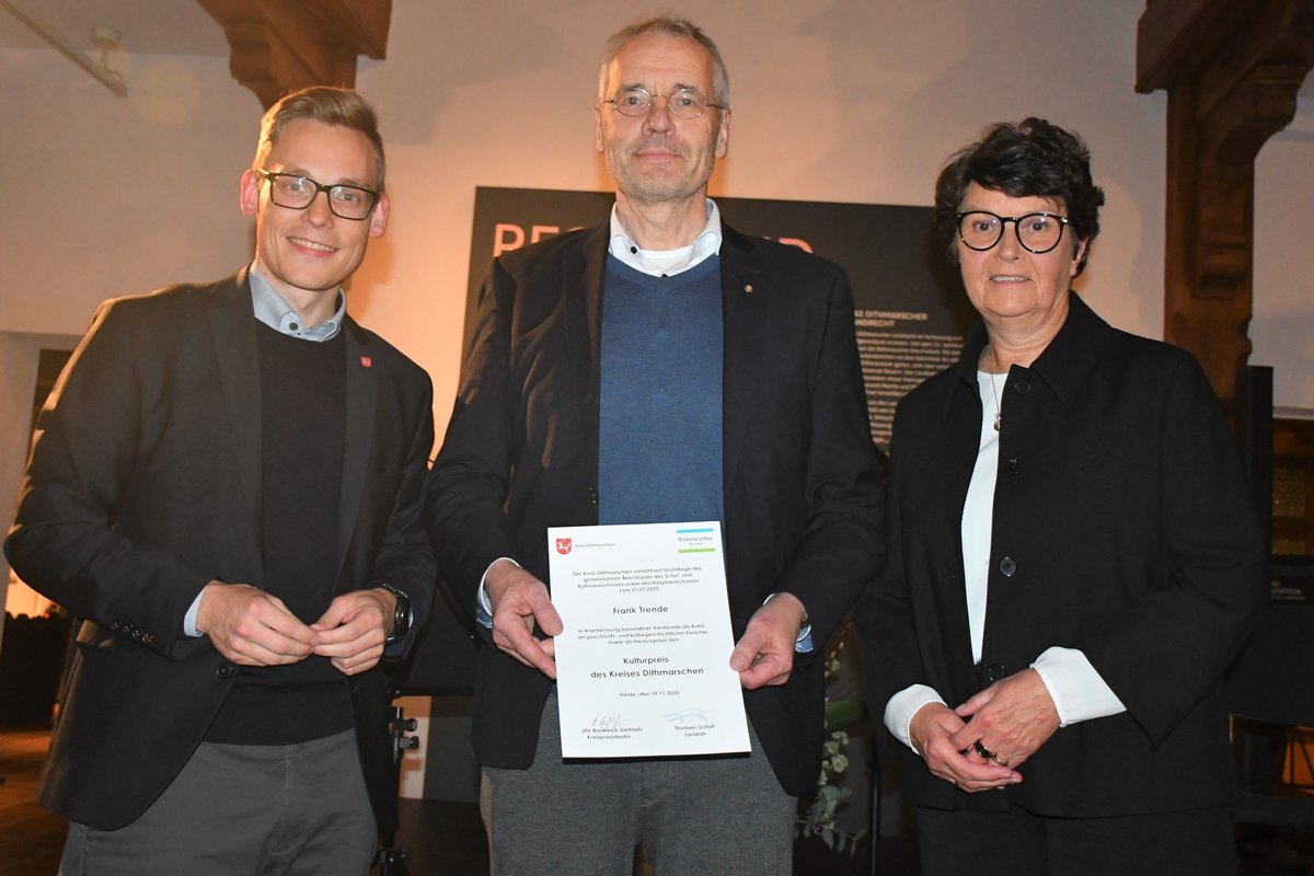 Landrat Thorben Schütt und Kreispräsidentin Ute Borwieck-Dethlefs gratulieren dem Preisträger Frank Trende. Foto: Kreis Dithmarschen