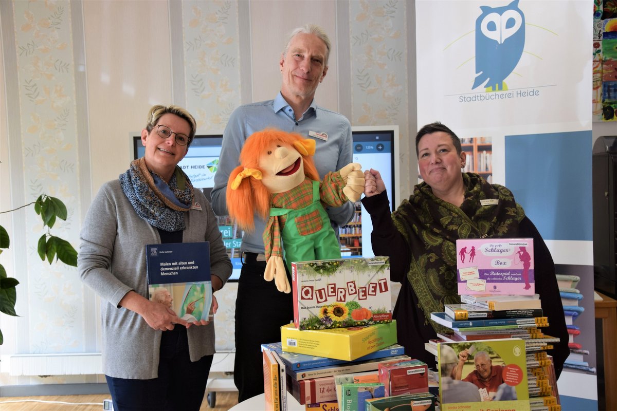 Die Demenz-Bibliothek in der Stadtbücherei Heide bietet eine Vielzahl an Medien, die Anregungen und Hintergrundwissen für die Betreuung und den Umgang mit Demenzerkrankten enthalten (v. l.): Kerstin Magnussen (Pflegestützpunkt Dithmarschen), Gerd Schröder (Kreis Dithmarschen) und Michaela Liebster (Stadtbücherei Heide). Foto: Kreis Dithmarschen